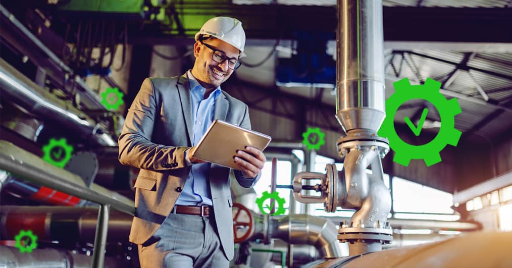 A manager wearing a hard hat carrying an iPad