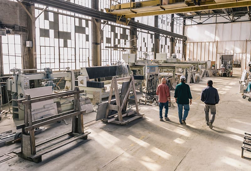 3 guys walking through a construction warehouse